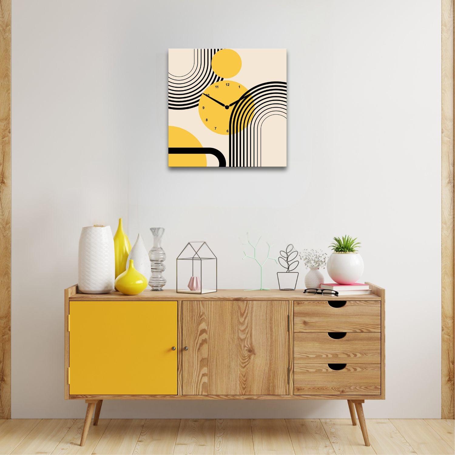 ambientazione di un orologio da parete quadrato sopra un mobile dai colori del legno chiaro e del giallo