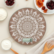 Bilancia digitale Mandala in vetro su piano cucina con farine, frutta secca e utensili in legno