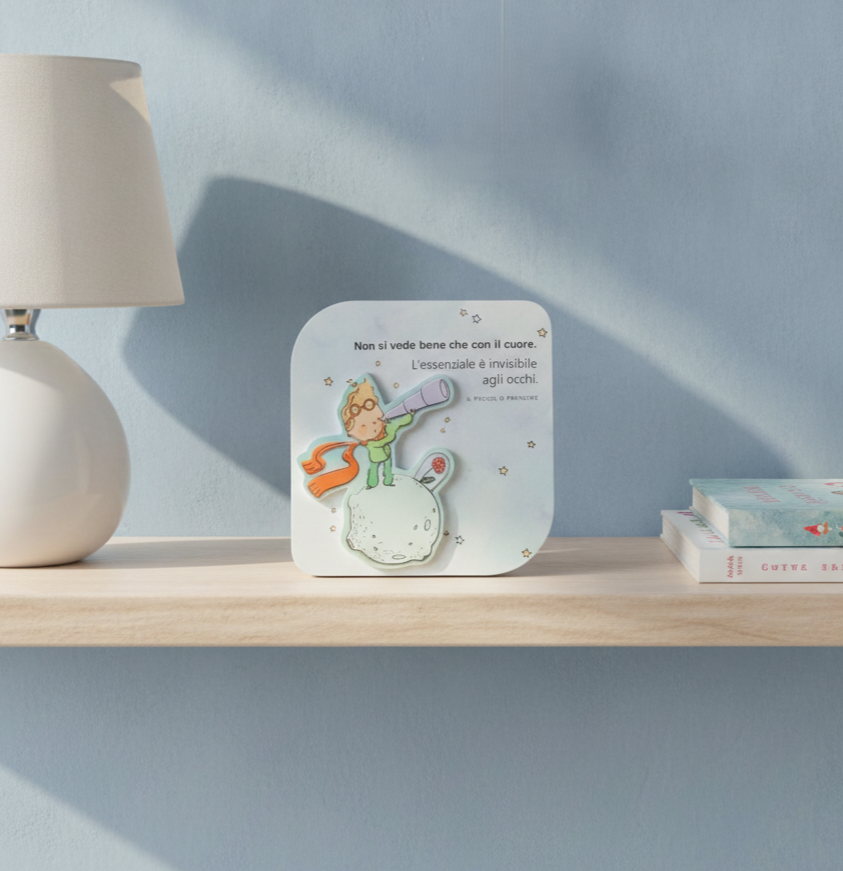Quadretto 3D del Piccolo Principe con frase, ambientato su una mensola in cameretta dai toni azzurri.