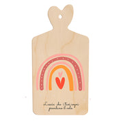 Tagliere in legno a forma di cuore con arcobaleno stilizzato nei toni rosa e arancio e frase “Lascia che i tuoi sogni prendano il volo” nella parte inferiore.