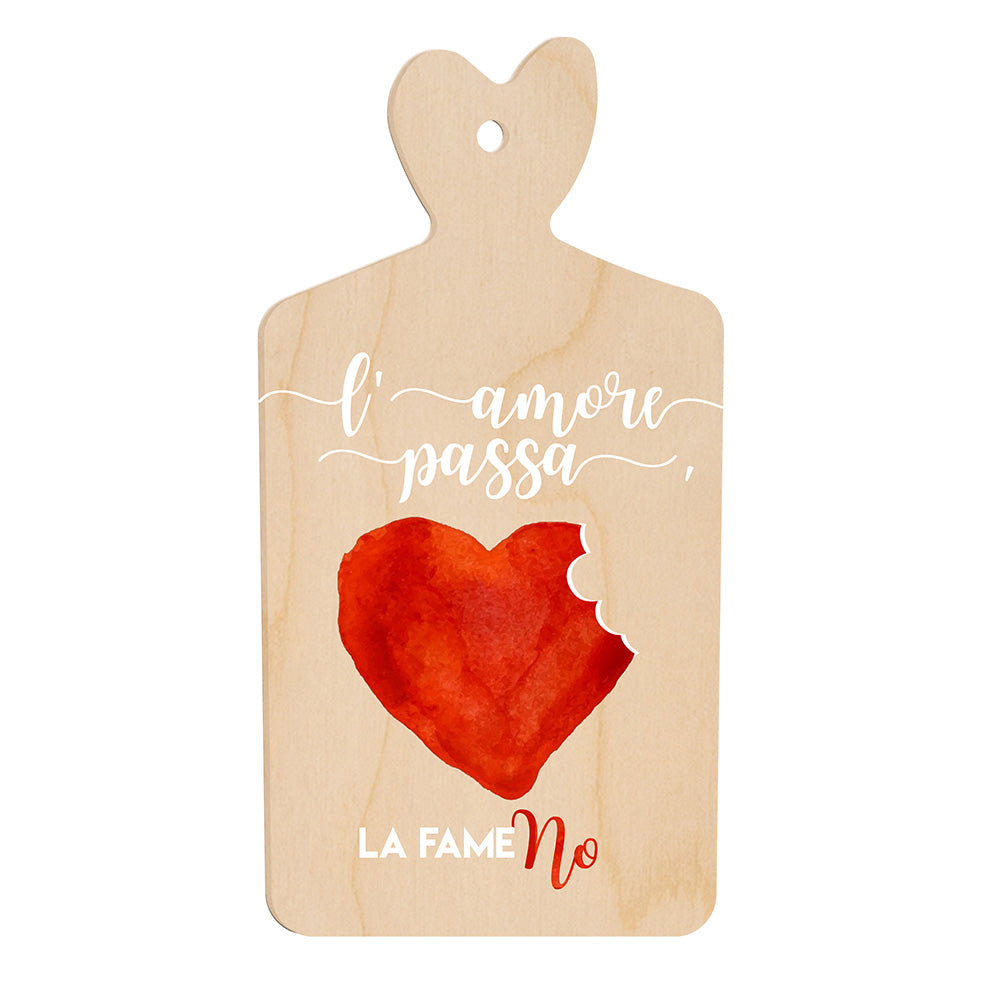 Tagliere in legno a forma di cuore con frase “L’amore passa, la fame no” e illustrazione di un cuore rosso con un morso sul lato destro.
