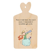 Tagliere in legno a forma di cuore con la frase “L’essenziale è invisibile agli occhi” e illustrazione del Piccolo Principe su un pianeta.