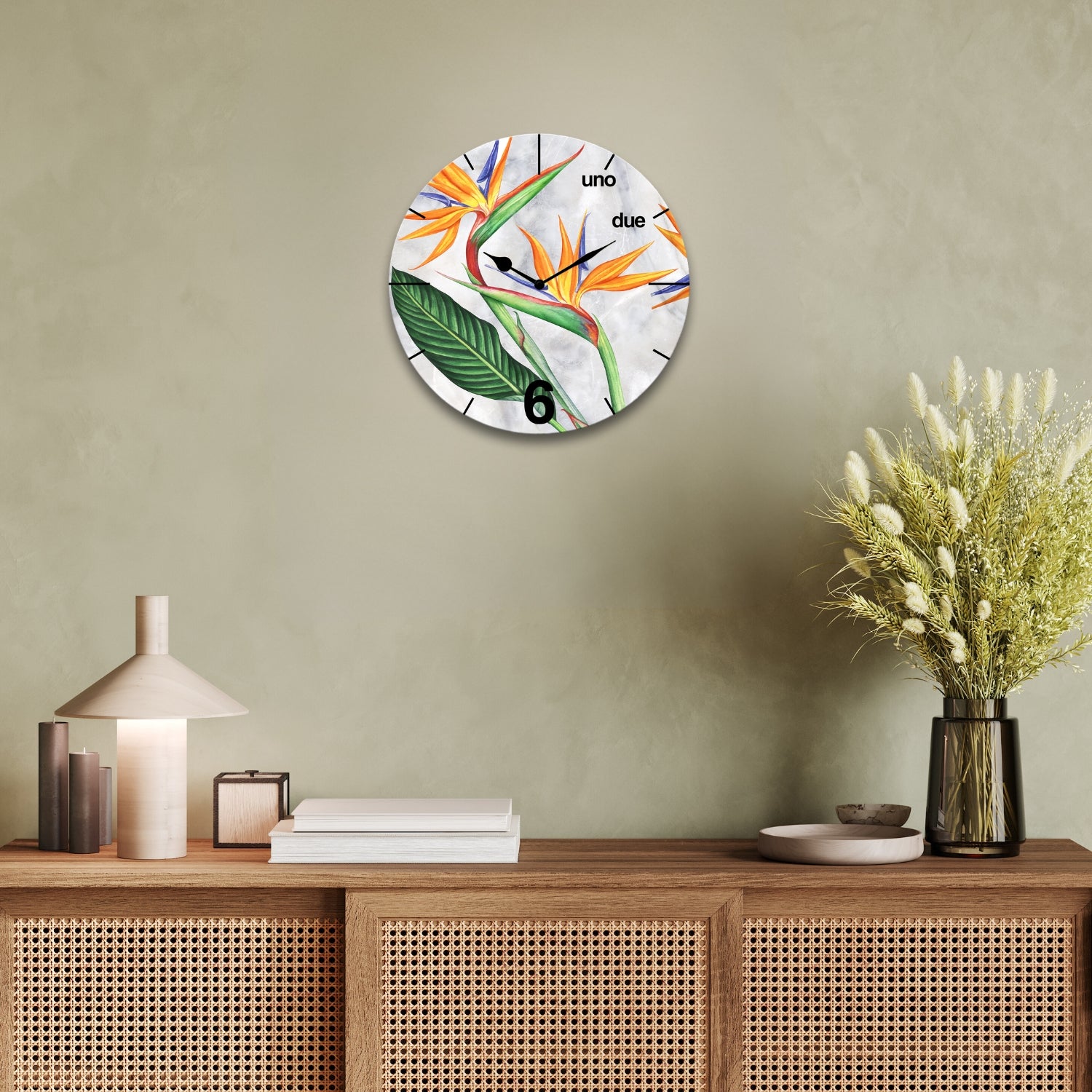 orologio da parete tondo raffigurante il fiore del paradiso sopra una madia 