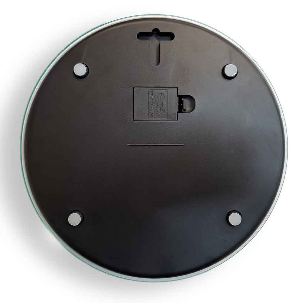 Vista posteriore di una bilancia digitale rotonda con fondo in plastica nera, piedini antiscivolo e vano batteria centrale.