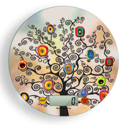 Bilancia digitale con decoro ad albero nero e cerchi concentrici variopinti su sfondo sfumato blu, lilla e rosa dall’effetto pittorico.