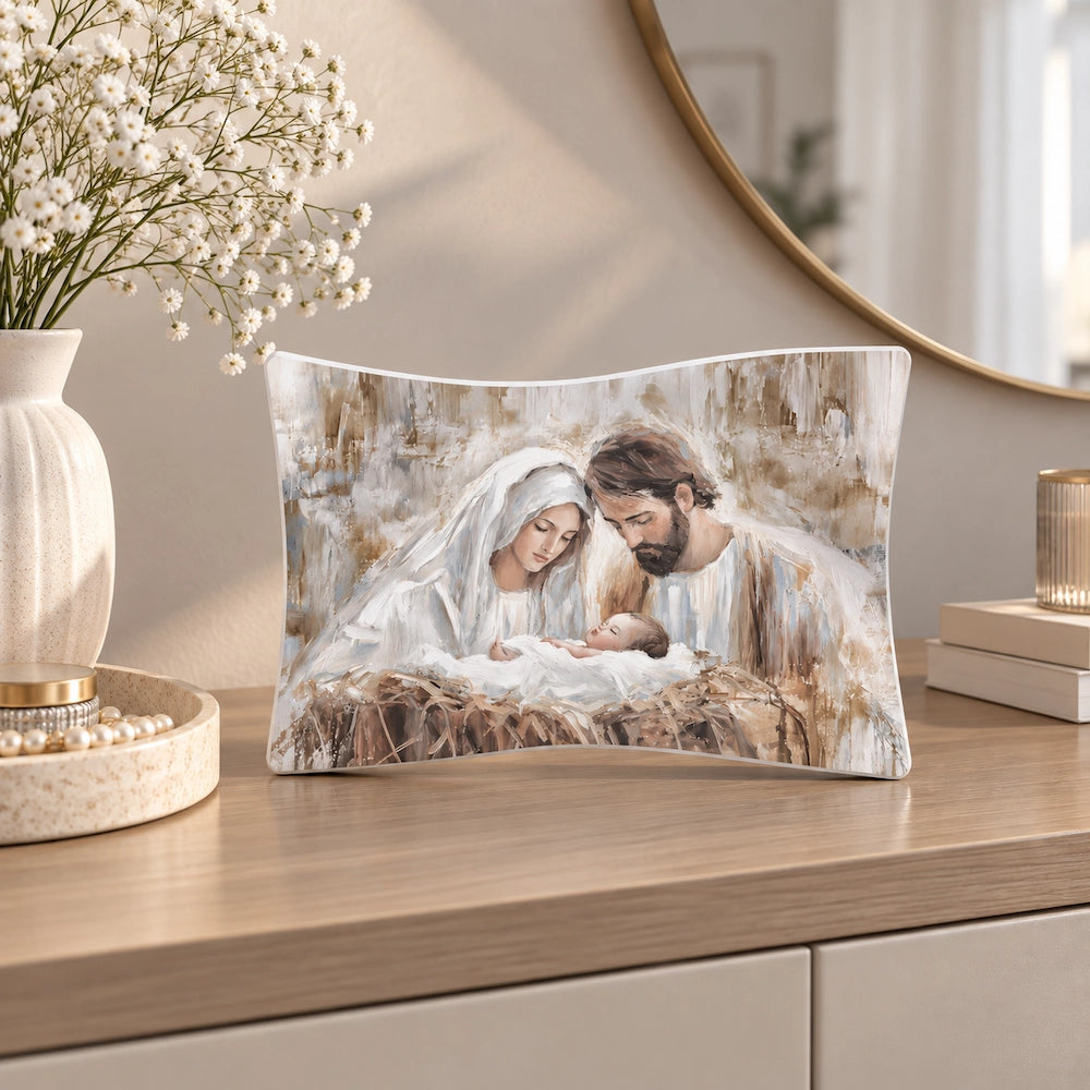 Bomboniera Sacra Famiglia in tonalità beige e tortora e in stile pittorico, ambientata su mobile moderno con fiori bianchi e dettagli decorativi neutri.