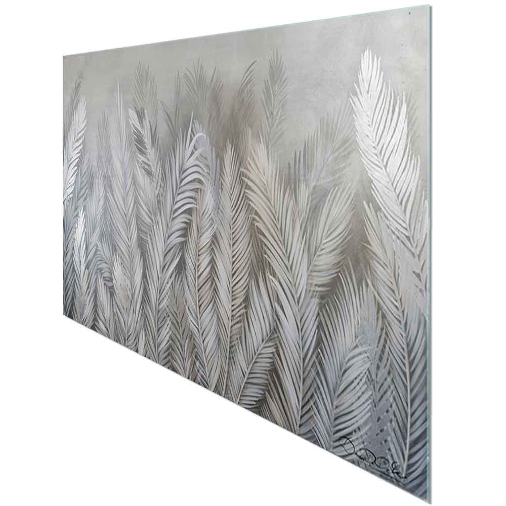 Quadro in plexiglass o vetro con foglie tropicali argentate su sfondo scuro, visto lateralmente con riflessi lucidi.