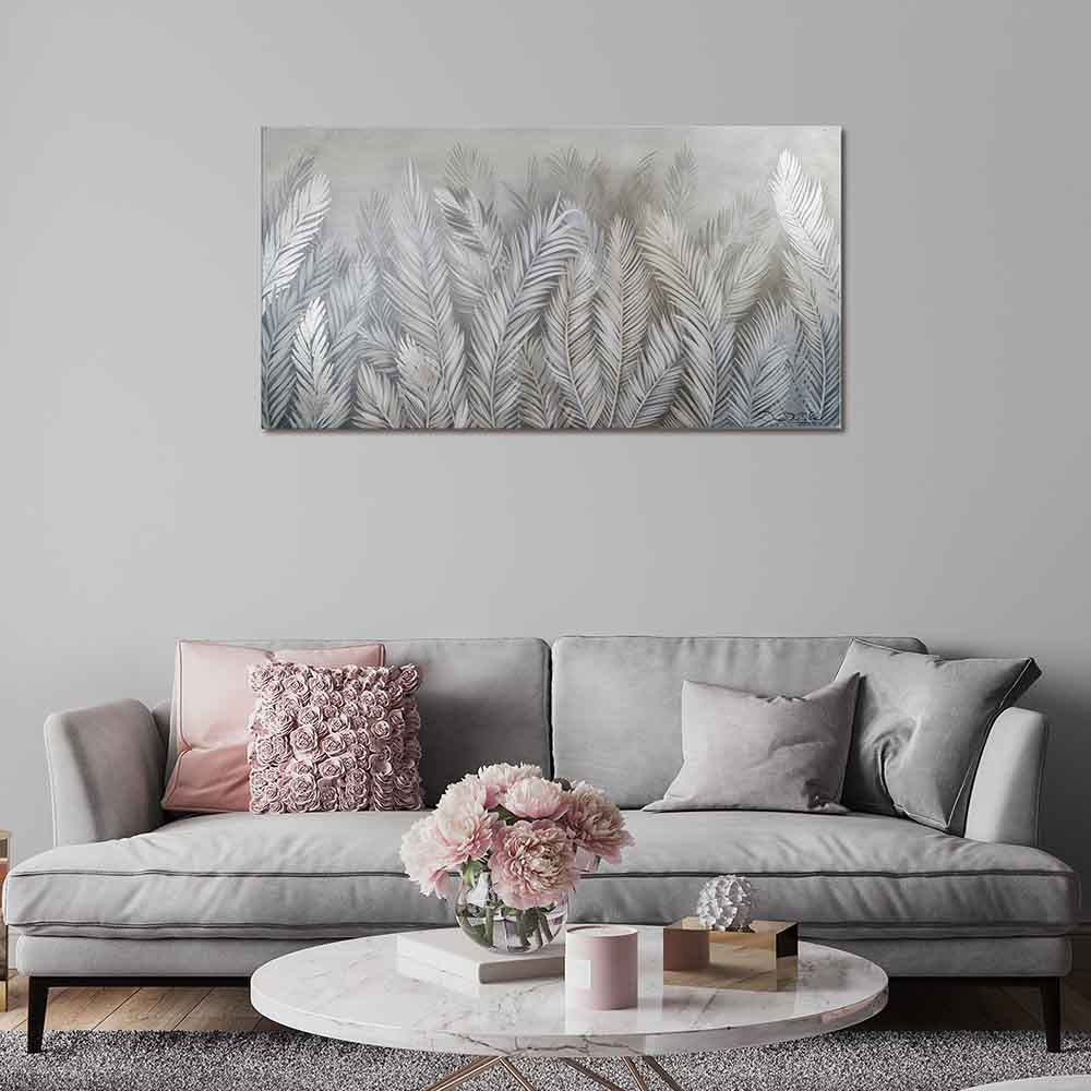 Quadro in plexiglass o vetro con decoro tropicale argento, montato in soggiorno moderno dai toni profondi e raffinati.