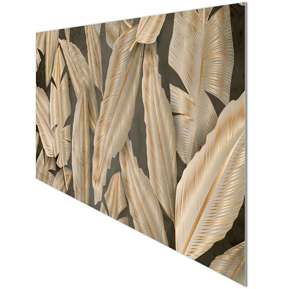 Quadro in plexiglass o vetro con grandi foglie dorate su fondo scuro, visione laterale che evidenzia la brillantezza della superficie.