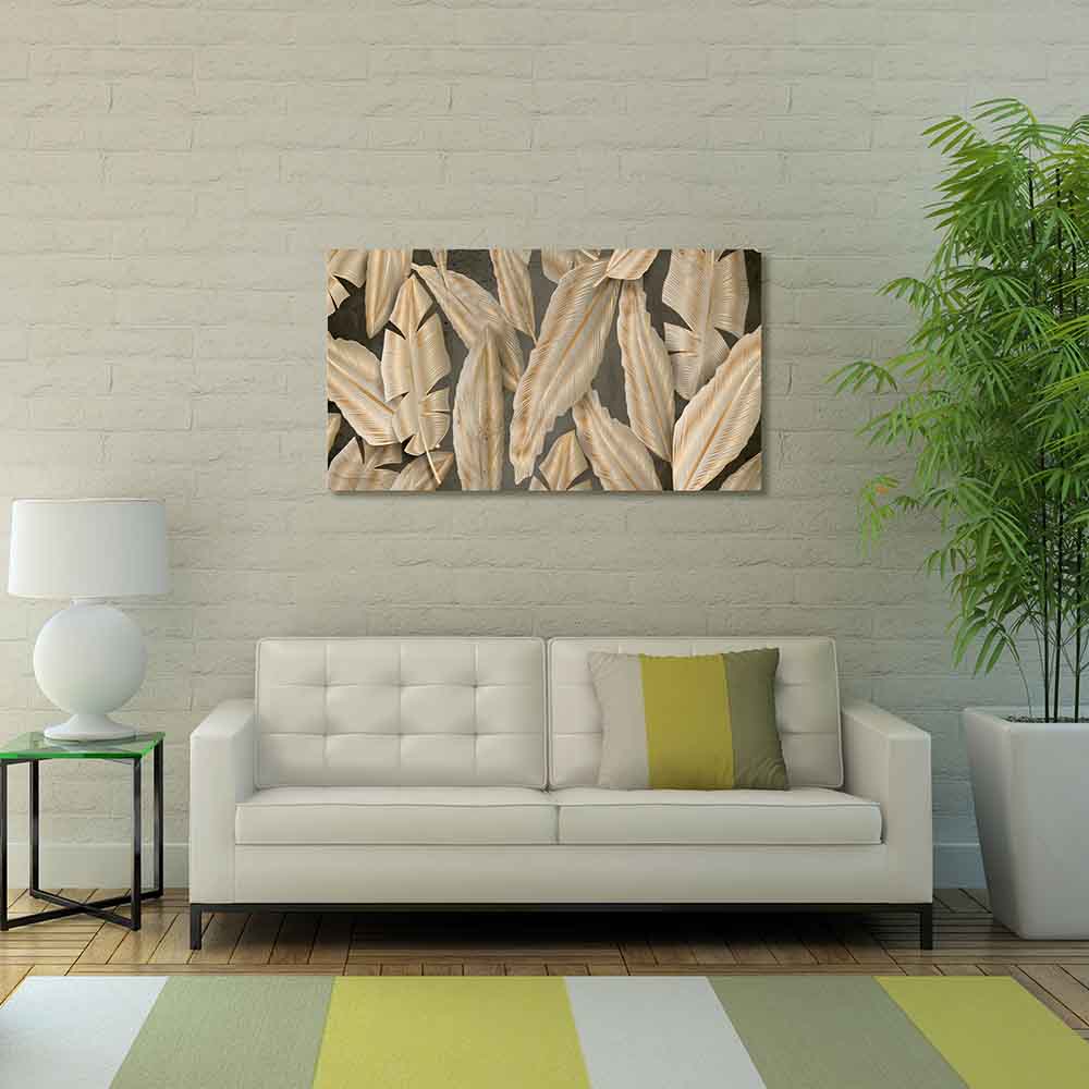 Quadro in plexiglass o vetro con eleganti foglie dorate su parete scura, montato sopra divano chiaro in salotto moderno.