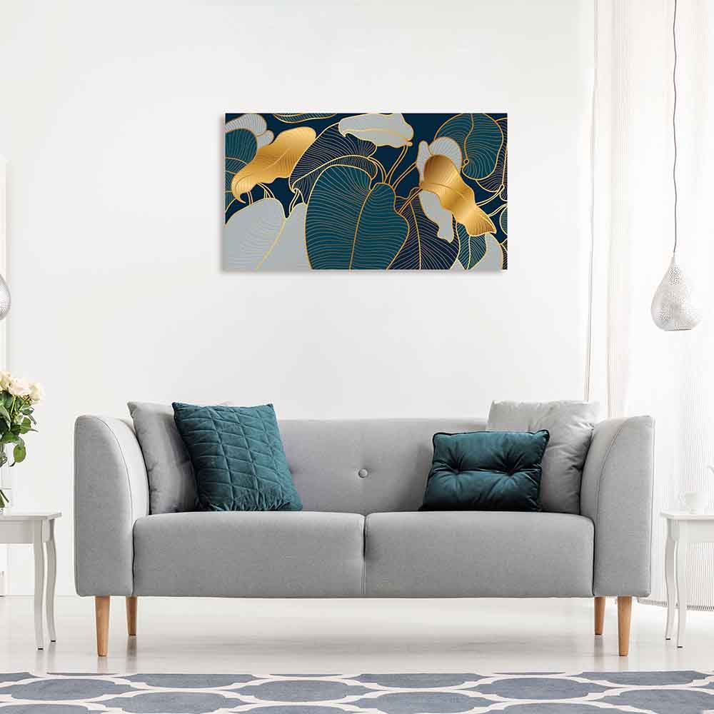 Quadro in plexiglass o vetro con foglie dorate su sfondo blu notte, sopra divano grigio in salotto elegante con arredi dai toni freddi.