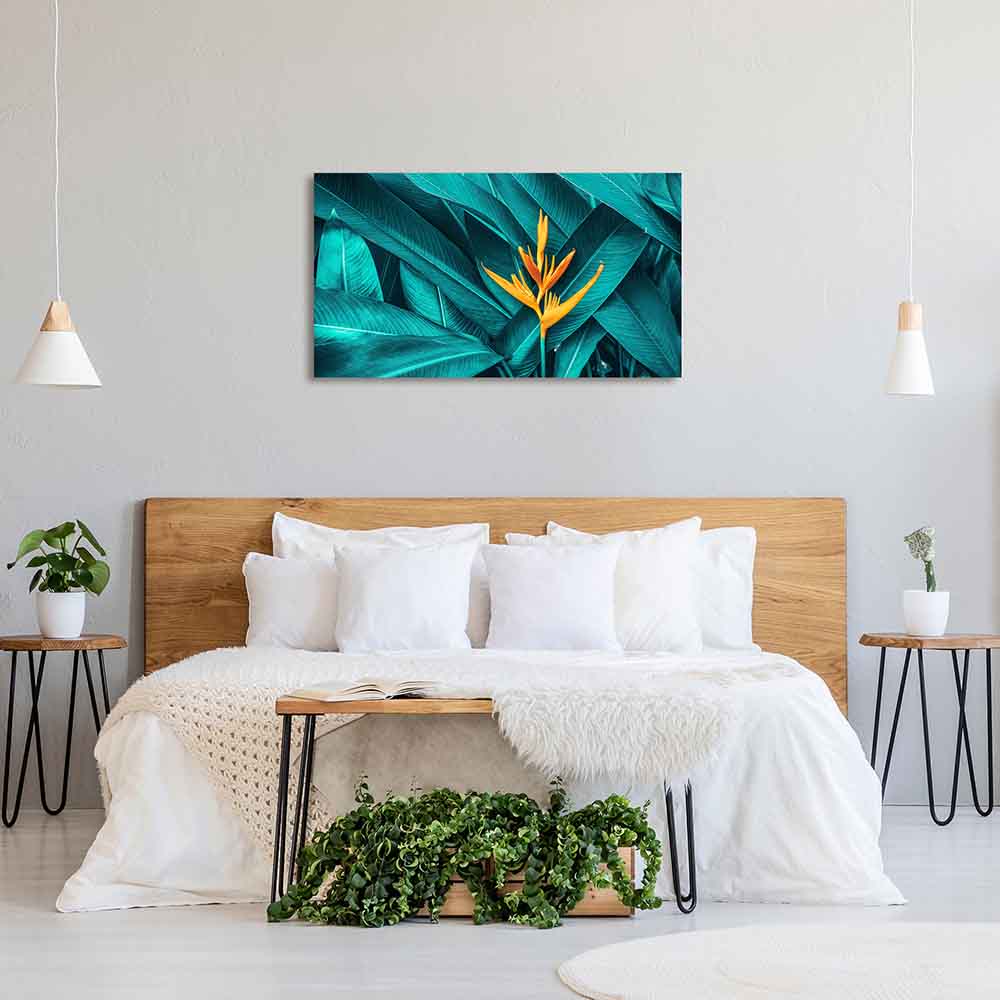 Quadro in plexiglass o vetro con fiore arancione su fondo tenue, montato su muro sopra un letto in camera luminosa dallo stile fresco.