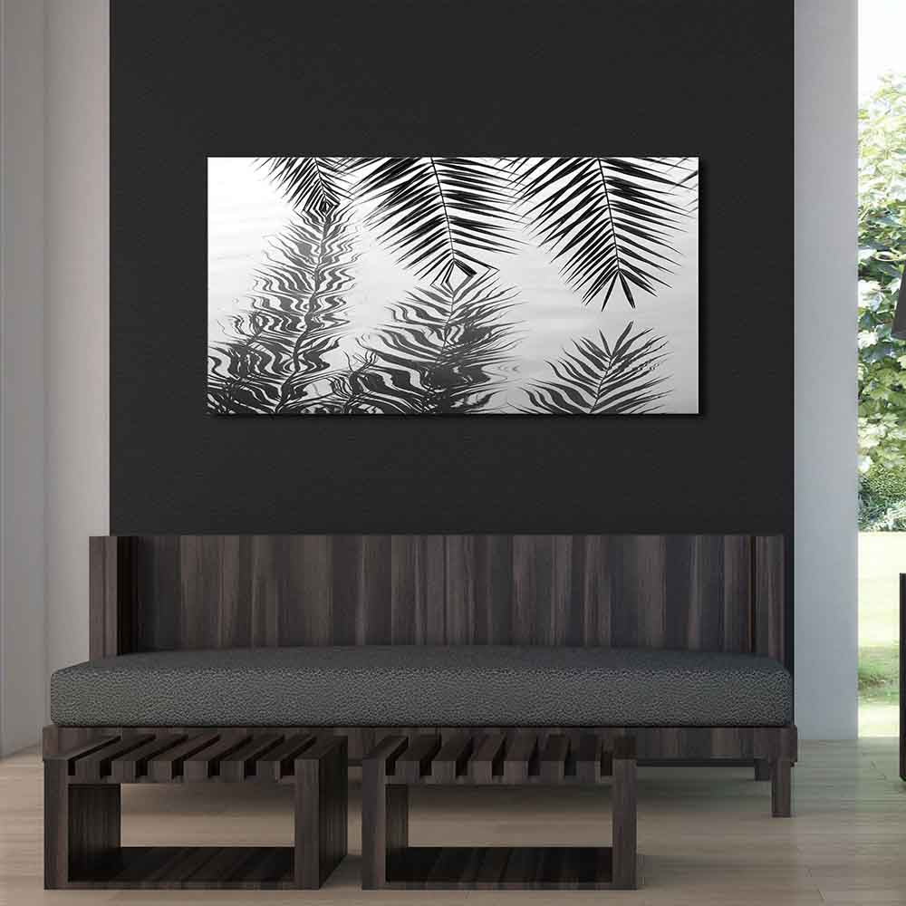 Quadro in plexiglass o vetro con foglie di palma riflesse nell'acqua, appeso su parete scura in soggiorno moderno dai toni naturali.