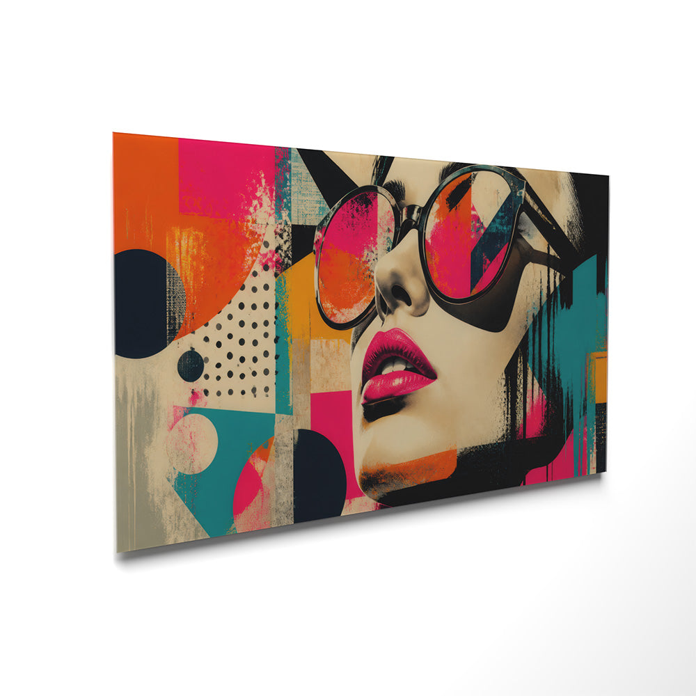 Quadro in vetro pop art vista laterale: volto femminile con occhiali neri oversize labbra magenta su sfondo geometrico multicolore