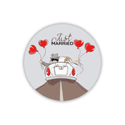 Magnete bianco con sposi in auto cabriolet, palloncini rossi a cuore e scritta Just Married. Illustrazione a colori per bomboniera nozze.