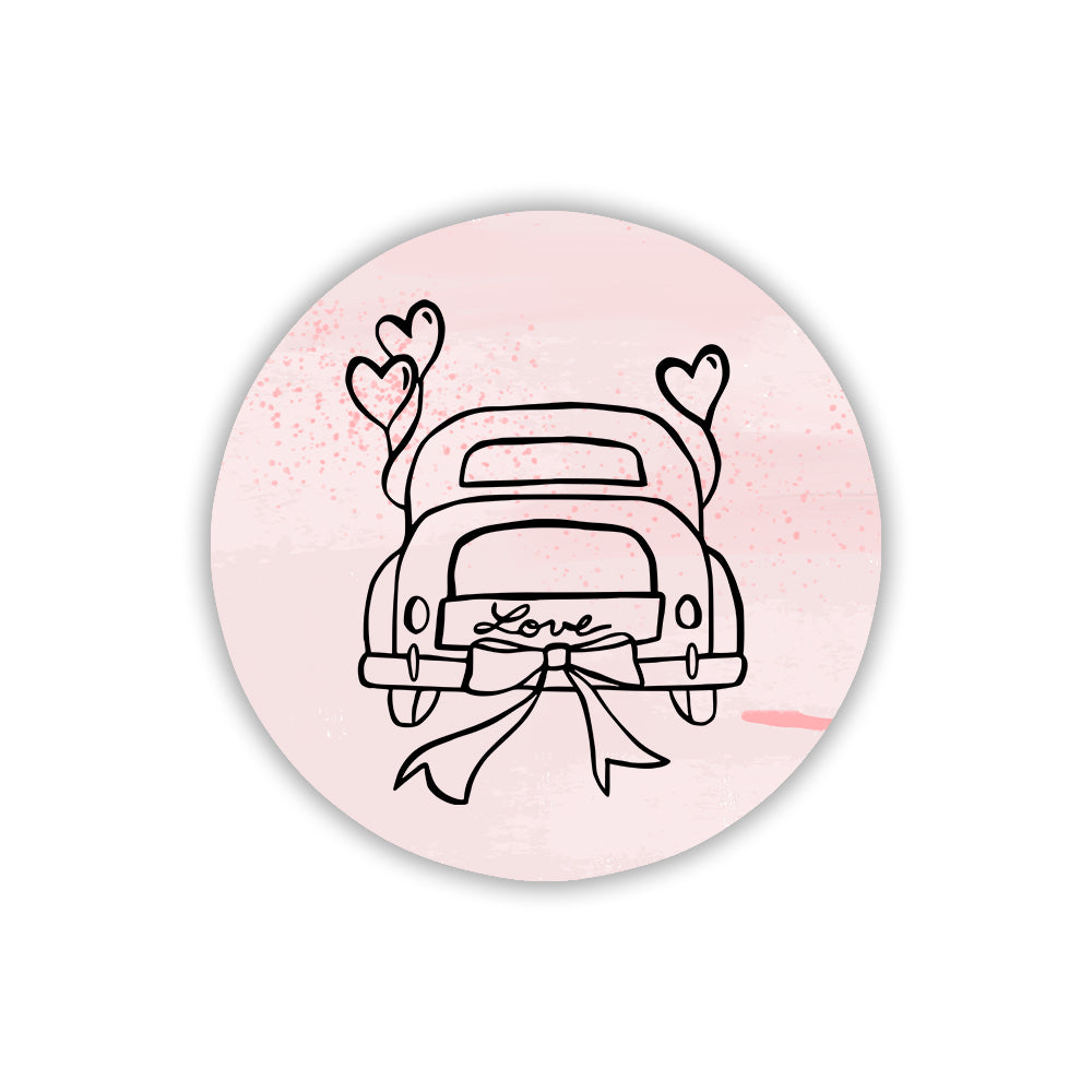 Calamita tonda in legno rosa con auto d'epoca, cuori volanti e fiocco. Illustrazione romantica per bomboniera matrimonio a tema viaggio.