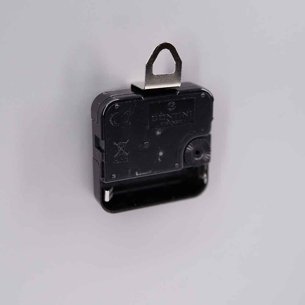 Vista laterale del retro di un orologio in alluminio, evidenziando i dettagli della struttura, il supporto per il montaggio e il meccanismo.