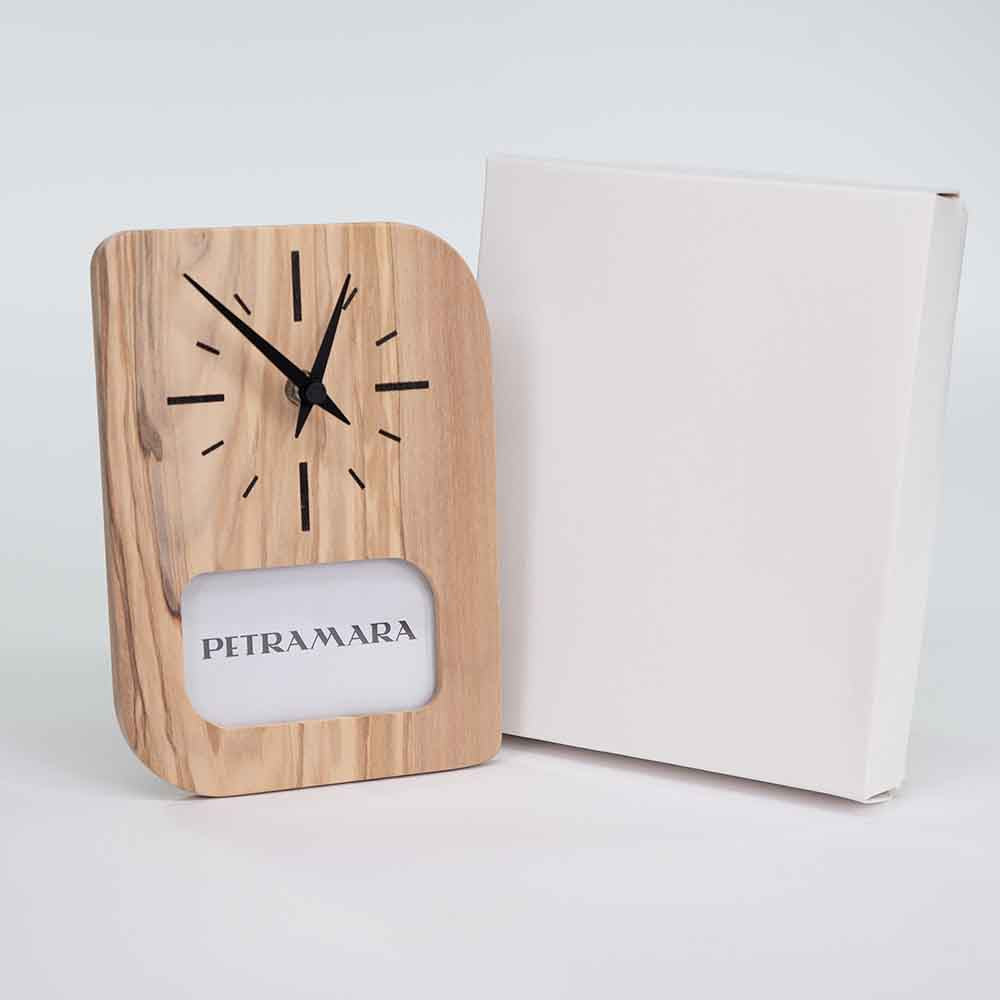 Orologio portafoto in ulivo accanto alla sua scatola di confezione, con il packaging posizionato in verticale.