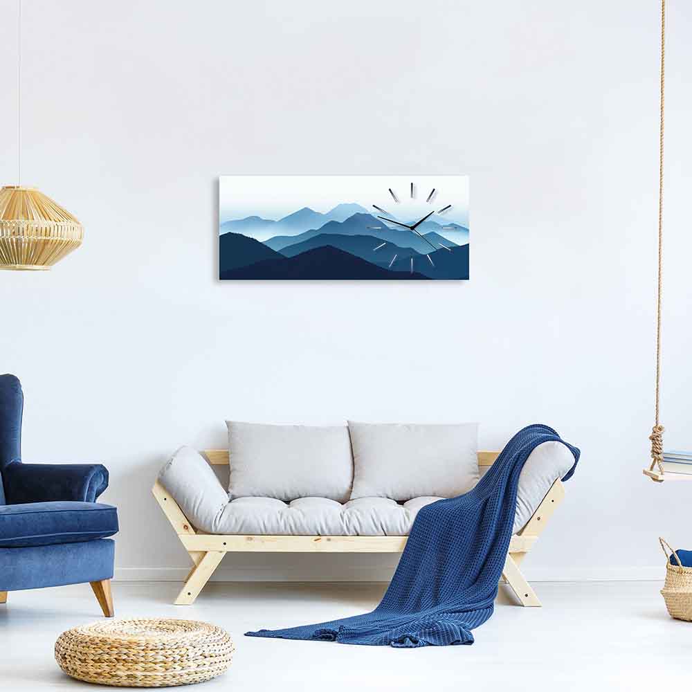 Orologio in plexiglass con paesaggio montuoso blu sfumato, collocato in un elegante soggiorno con arredamento minimalista.