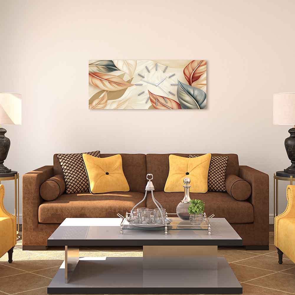 Orologio in plexiglass con pattern di foglie dorate su fondo neutro, inserito in un soggiorno dal design raffinato.