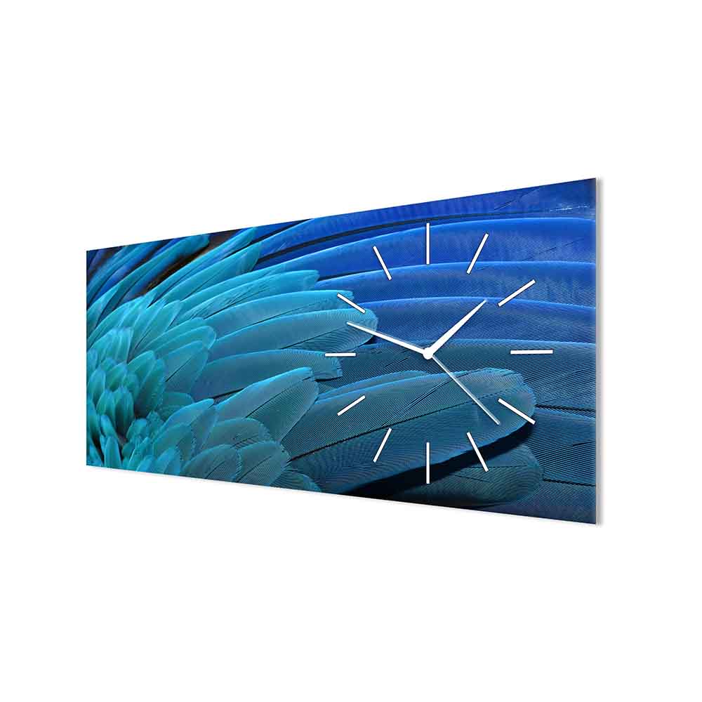 Vista laterale di un orologio in plexiglass con un decoro di piume dal tono blu, enfatizzando l’eleganza e la leggerezza del design.