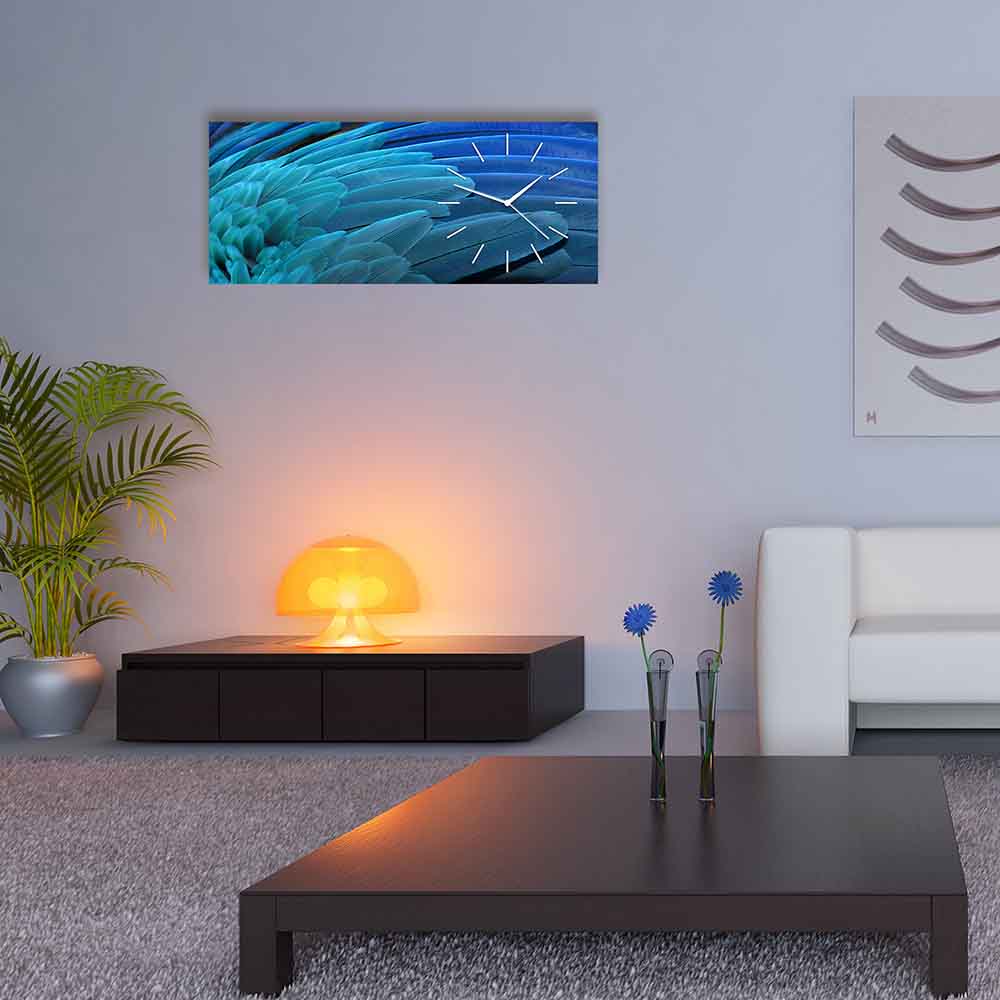 Orologio in plexiglass con elegante motivo di piume blu in varie sfumature di blu, inserito in un soggiorno dal design armonioso e rilassante.