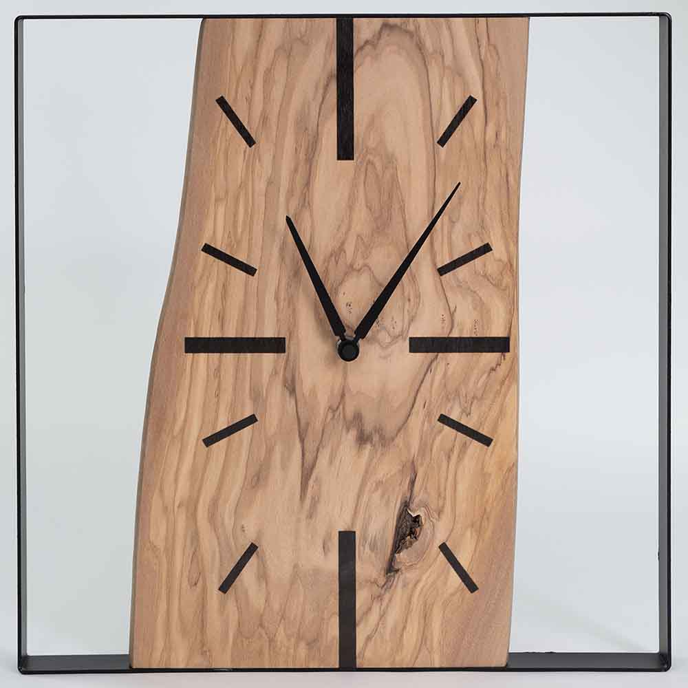 Vista frontale dell'orologio ulivo acciaio da parete, con quadrante ben visibile e armoniosa combinazione di materiali.