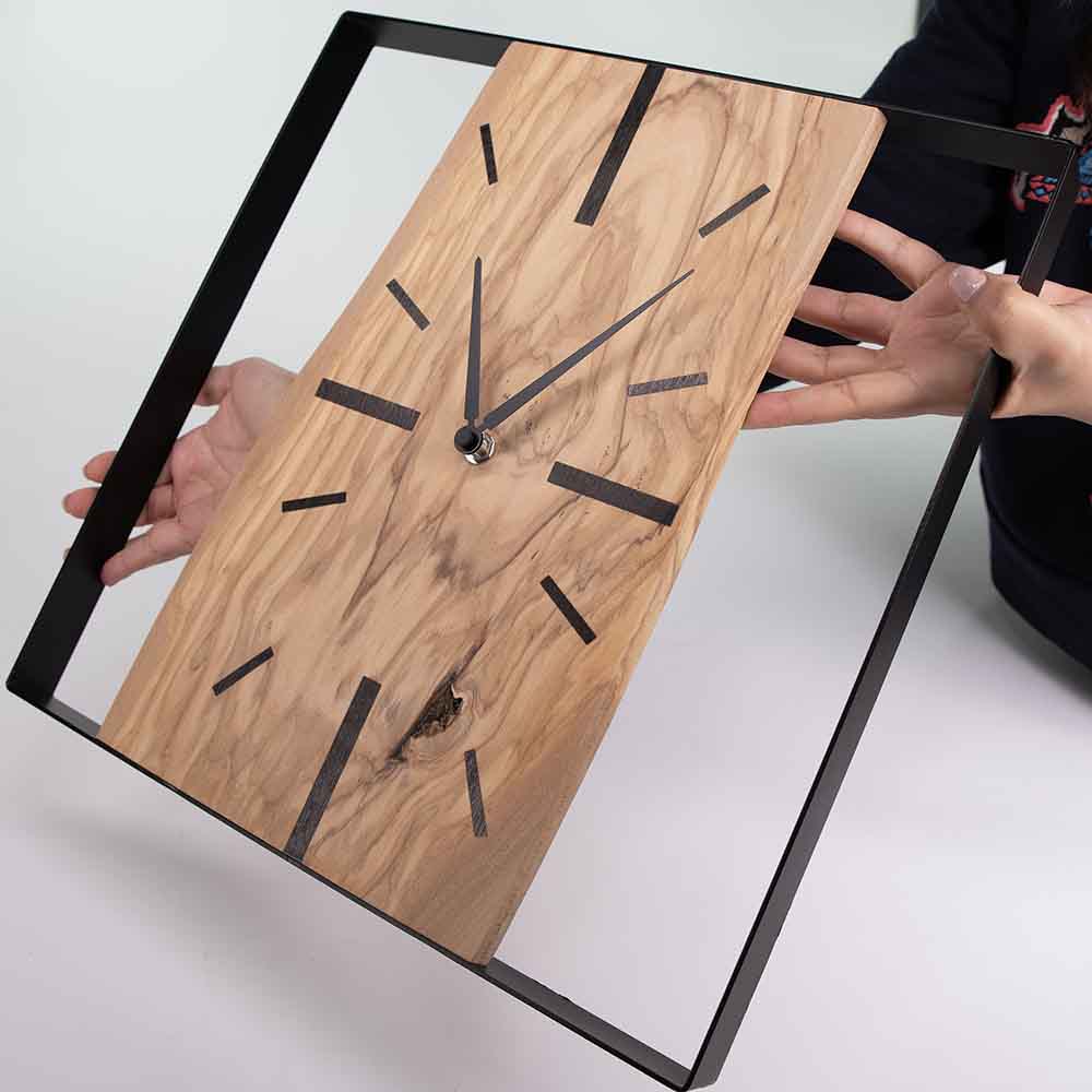 Vista laterale dell'orologio ulivo acciaio da parete, prospettiva che evidenzia profondità e materiali.