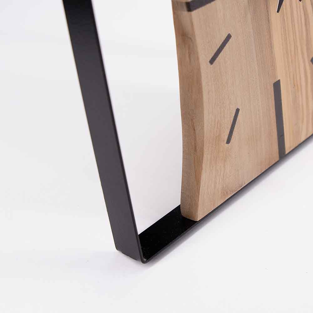 Orologio da tavolo in legno di ulivo e acciaio, angolo che evidenzia la struttura e il contrasto tra i materiali.