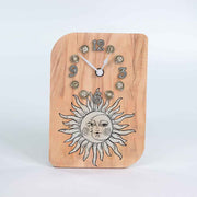 Orologio in ulivo da tavolo con decorazione di un sole e una luna intrecciati, dettagli stilizzati in tonalità calde e naturali.