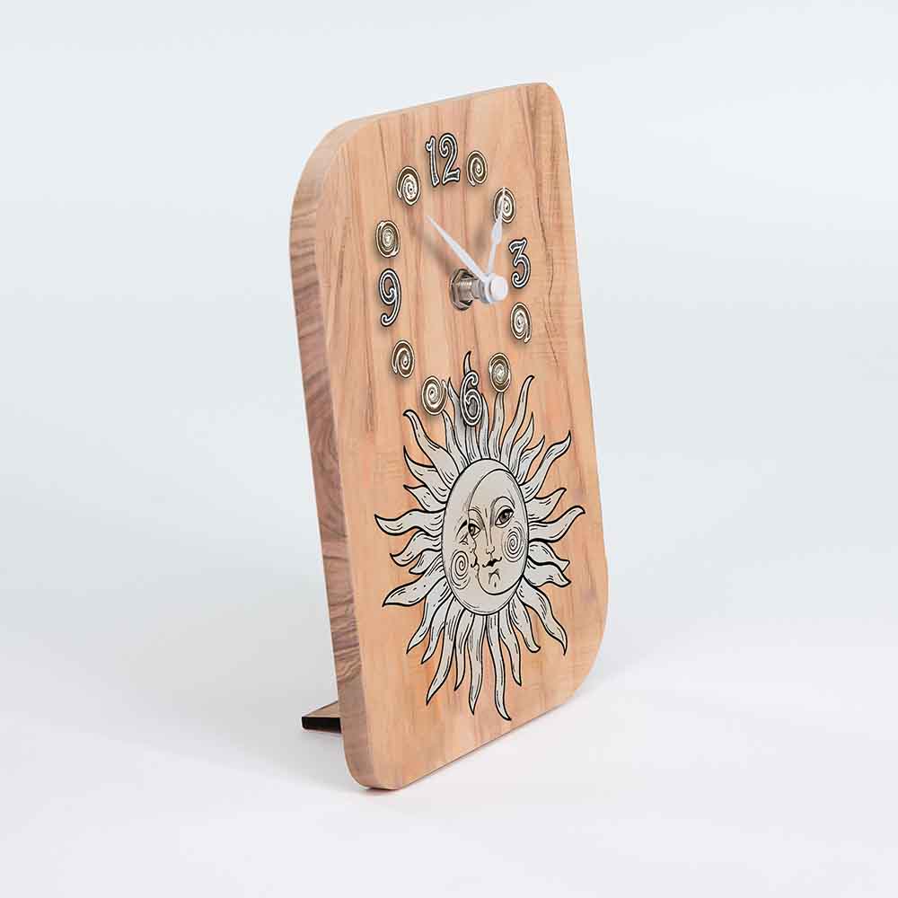 Vista laterale di un orologio in ulivo da tavolo con sole e luna intrecciati, portando in risalto lo spessore del legno e il design curvo.