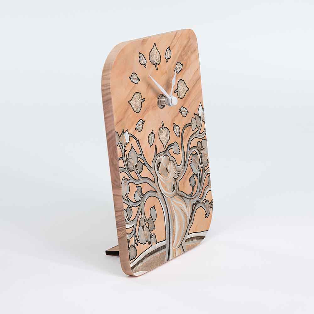Vista laterale di un orologio in ulivo da tavolo con due figure stilizzate in un abbraccio, mostrando la profondità del decoro.