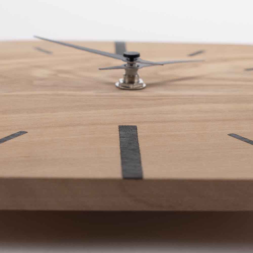 Orologio in ulivo da tavolo visto in prospettiva, evidenziando la struttura e la texture del legno levigato con dettagli raffinati.