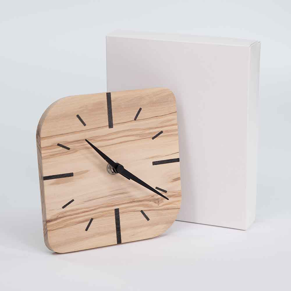 Orologio in ulivo da tavolo piccolo affiancato dalla sua confezione, posizionato frontalmente per valorizzare il design e la qualità artigianale.