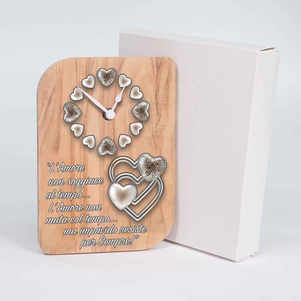 Orologio in ulivo da tavolo con cuori intrecciati adiacente alla sua confezione originale, un’idea regalo raffinata e romantica.