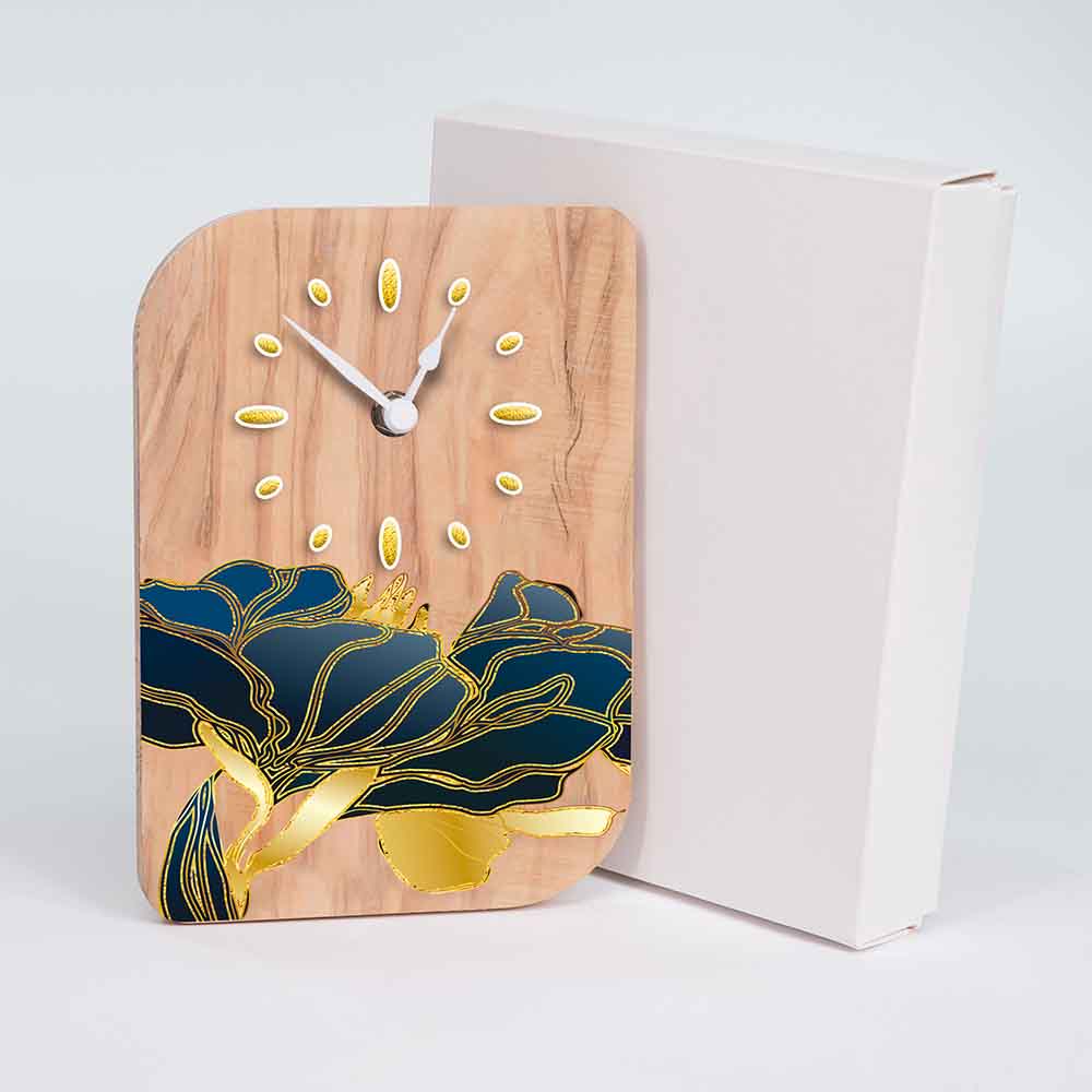 Orologio in ulivo da tavolo con fiori dorati prossimo alla sua confezione, perfetto per un regalo elegante e distintivo.