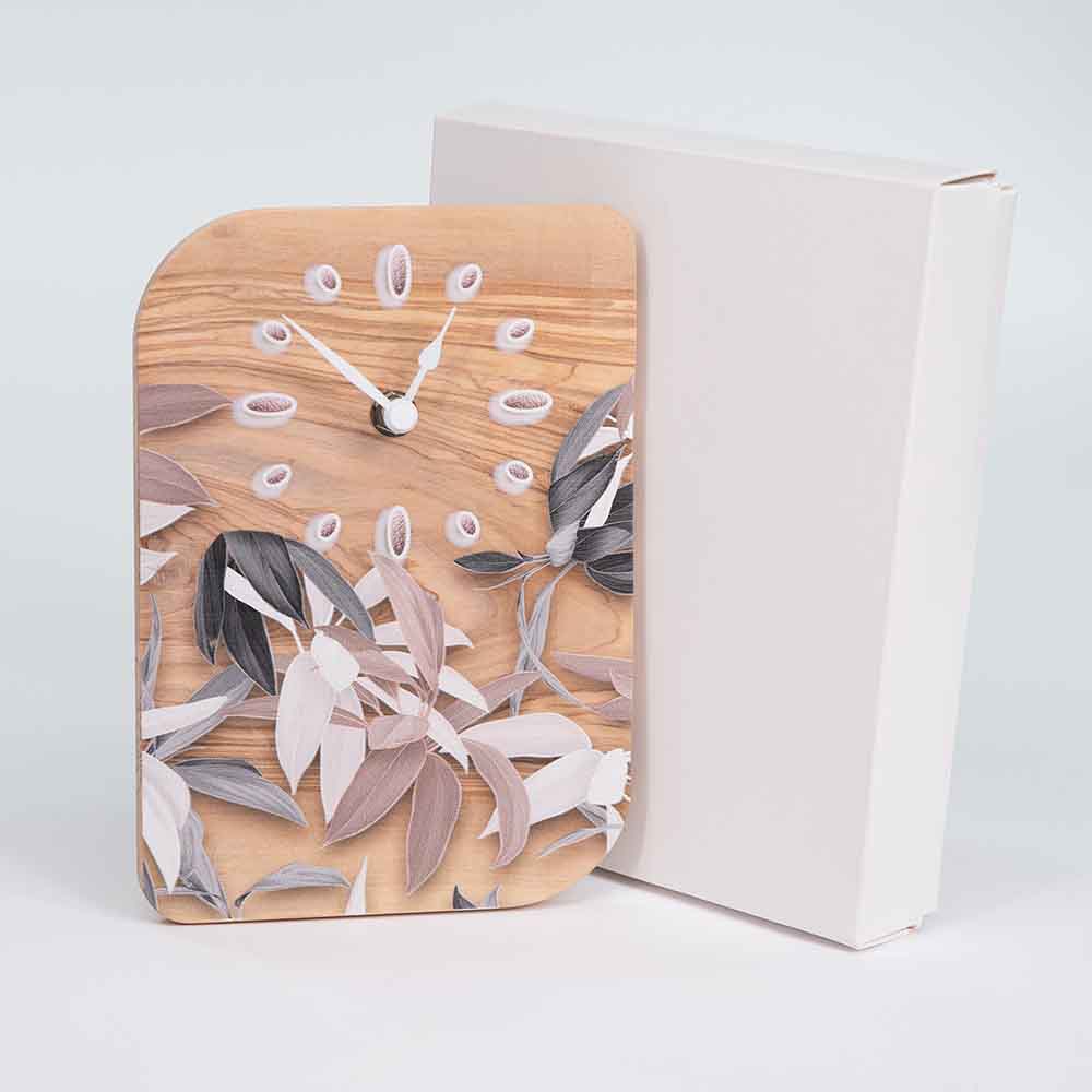 Orologio in ulivo da tavolo con decorazione a foglie, in prossimità del sua scatola, perfetto come dono raffinato e artigianale.