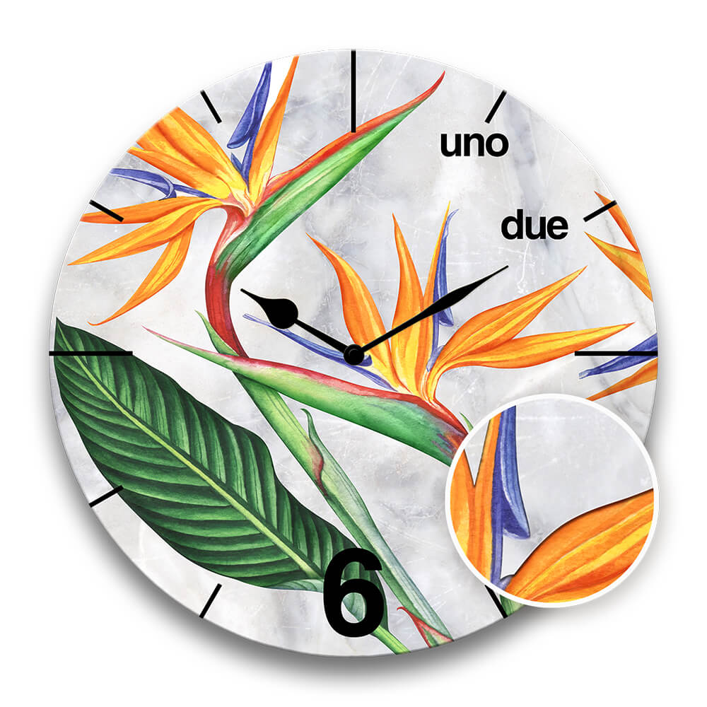 zoom su un dettaglio a rilievo di un orologio rotondo da parete con una strelitzia 