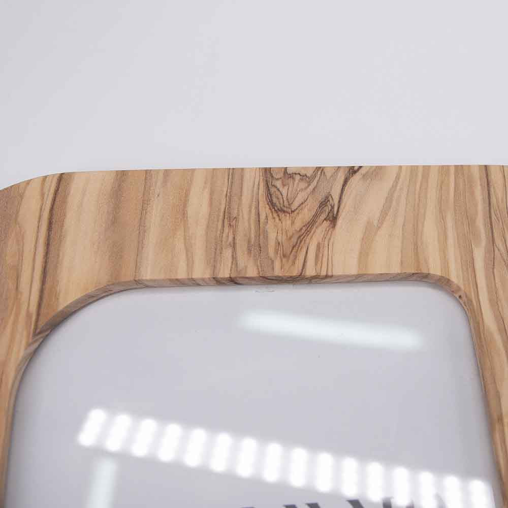 Dettaglio della parte superiore di un portafoto in legno di ulivo, con venature naturali ben visibili e angoli arrotondati.