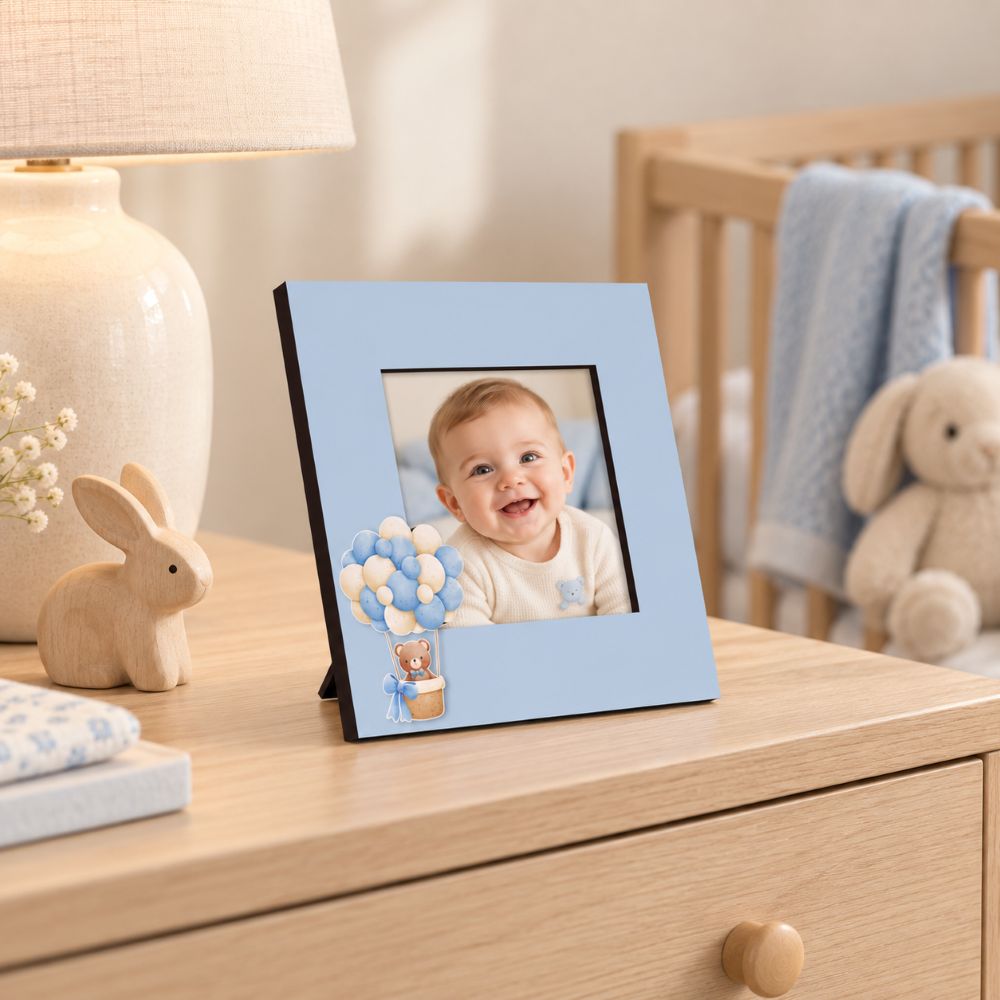 Portafoto azzurro Teddy Balloon da 15×15 cm con foto di un bambino, ambientato su una cassettiera in una cameretta elegante