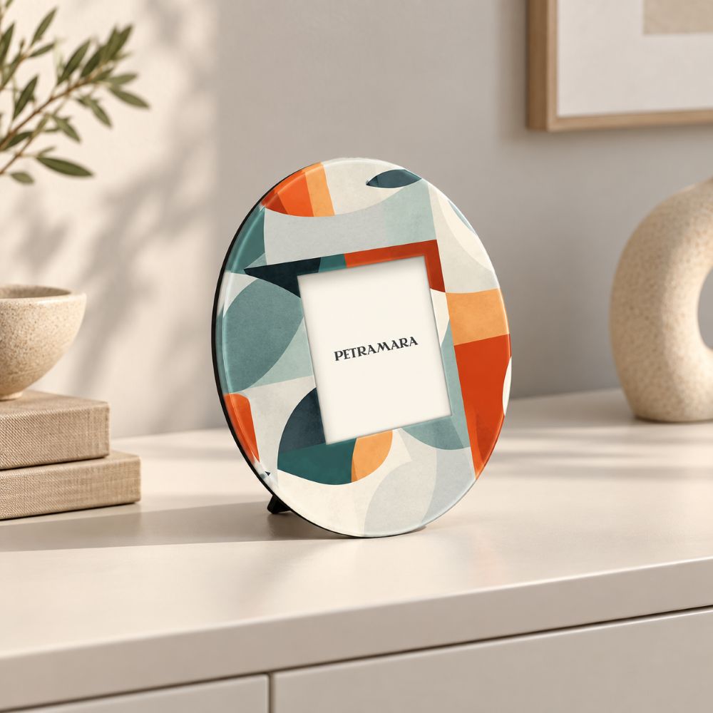 Portafoto rotondo in vetro Minimalist con forme geometriche verdi e arancioni, ambientato su una consolle chiara in un soggiorno moderno