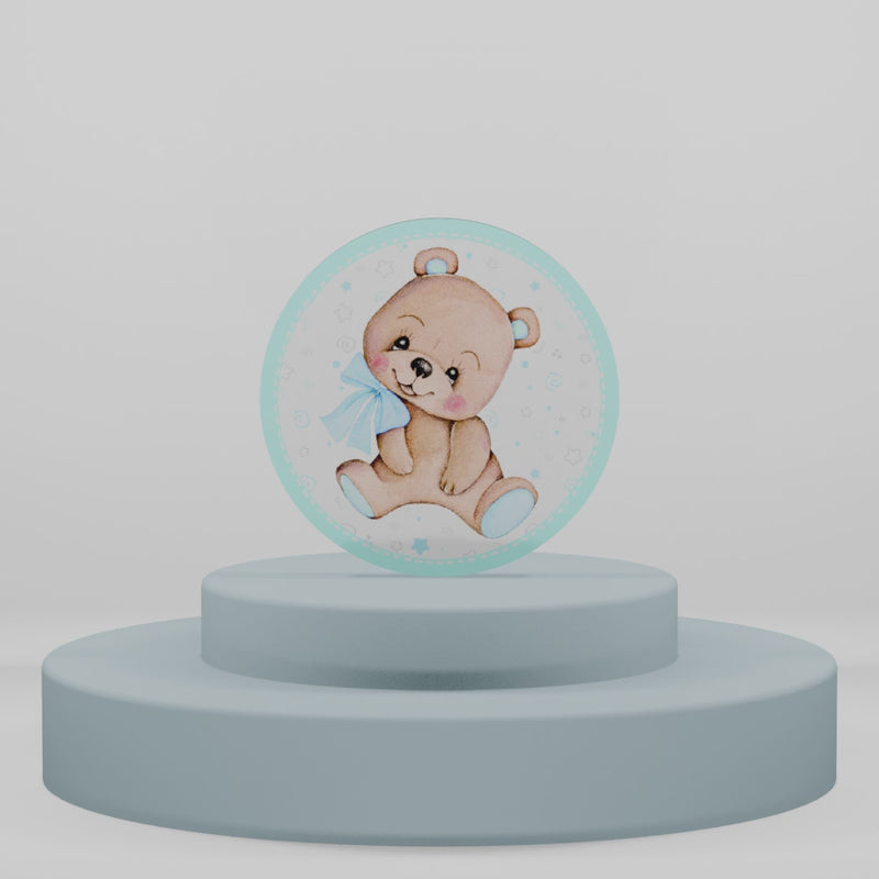 Magnete tondo in legno con orsetto marrone e fiocco azzurro su sfondo con stelle, perfetto per ricordini di nascita, battesimo o baby shower maschile.