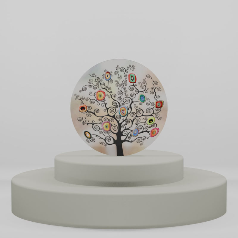 Magnete discoidale in legno con albero ornamentale a spirali e icone geometriche colorate su fondo sfumato beige e panna.