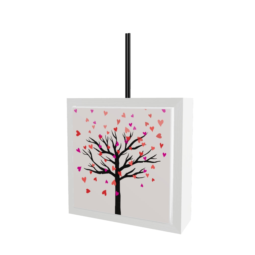 Modello 3D profumatore ceramica bianco con albero spoglio e foglie a forma di cuore rosa e rosse che cadono su sfondo crema chiaro