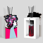 Profumatore bomboniera in legno con sagoma di donna stilizzata, capelli ornati da fiori colorati su fondo rosa e azzurro, design moderno ed elegante.