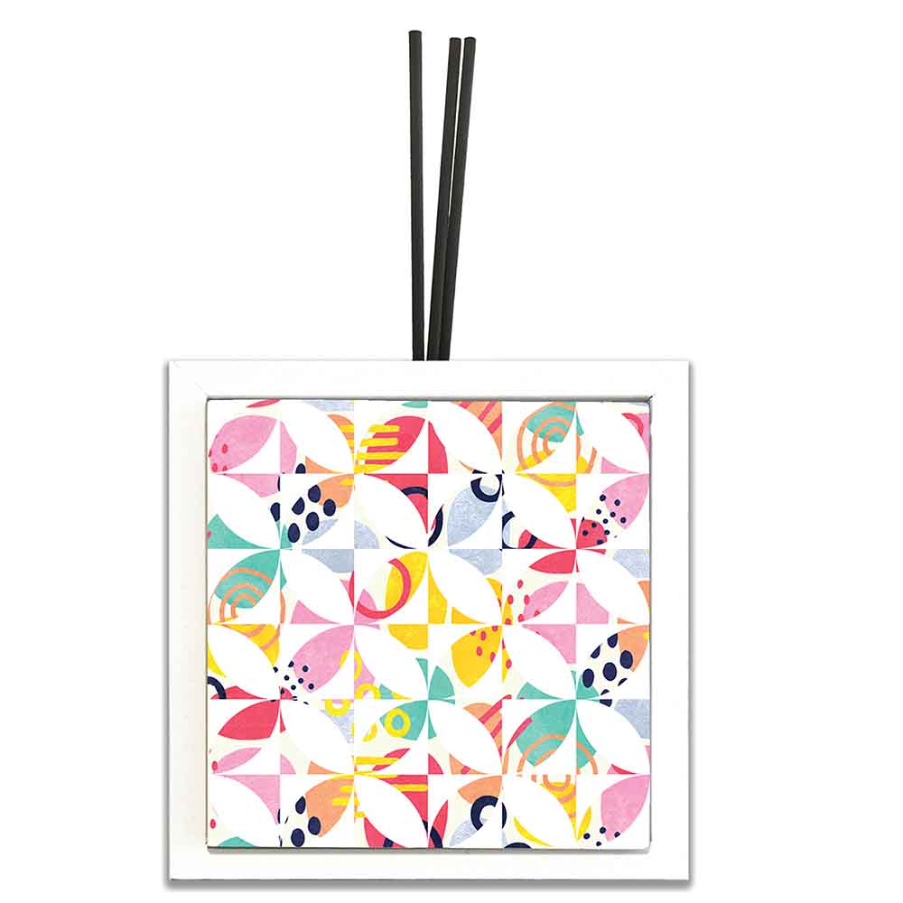 Profumatore ceramica bianco con motivi geometrici multicolori, forme curve e dettagli vivaci, completato da bastoncini diffusori.