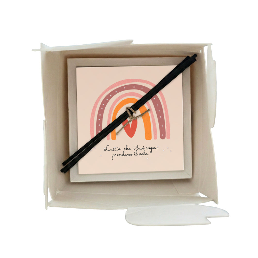 Profumatore ceramica in scatola, arco arcobaleno rosa bordeaux e arancio su sfondo crema, cuore rosso e scritta motivazionale, bastoncini reed neri