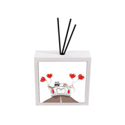 Profumatore ceramica bianco bomboniera matrimonio, sposi in auto decappottabile bianca con fedi e palloncini rossi a cuore su strada, bastoncini reed neri