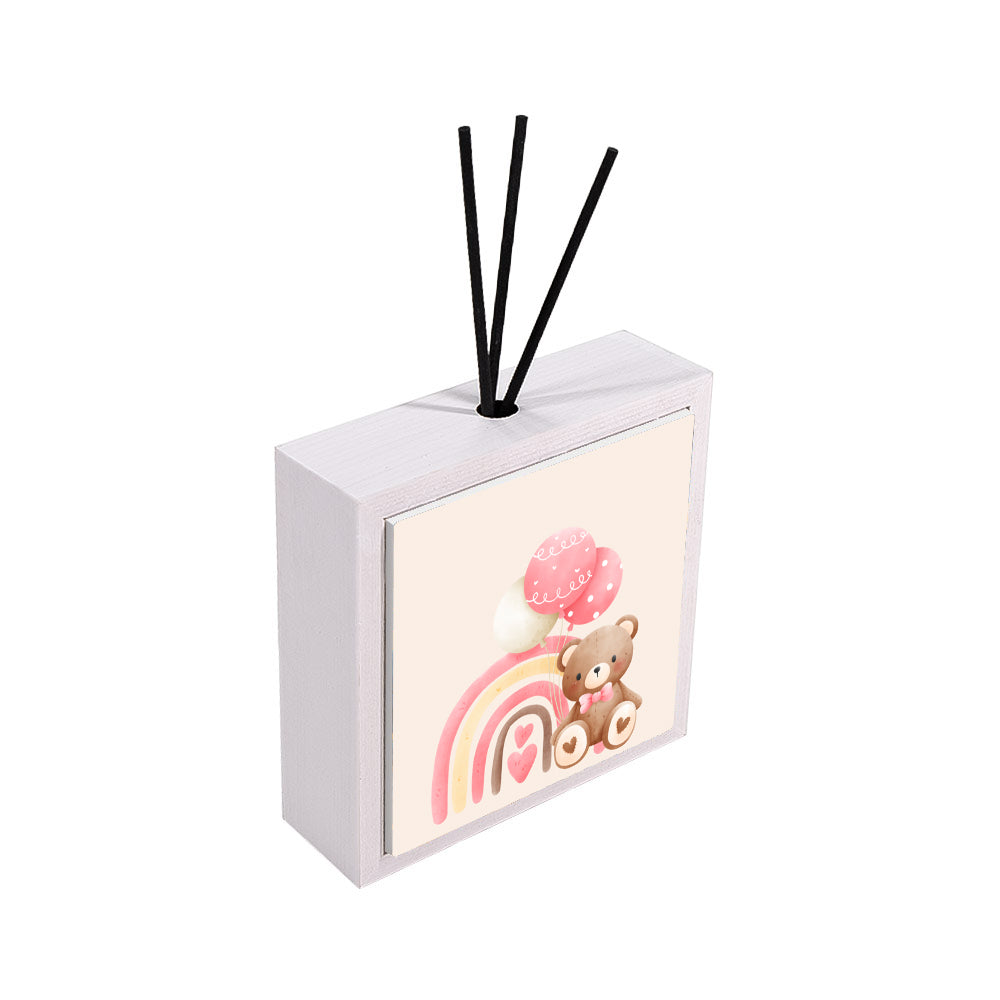 Profumatore ceramica bianco vista laterale, orsetto marrone con fiocco rosa, arcobaleno rosa e giallo con cuori, palloncini rosa su sfondo pesca, reed neri