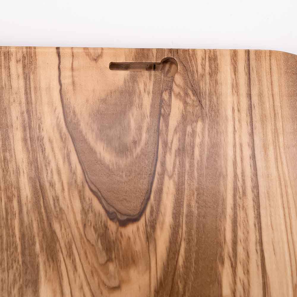 Dettaglio del foro posteriore di un quadretto in legno d'ulivo, progettato per essere appeso facilmente alla parete.